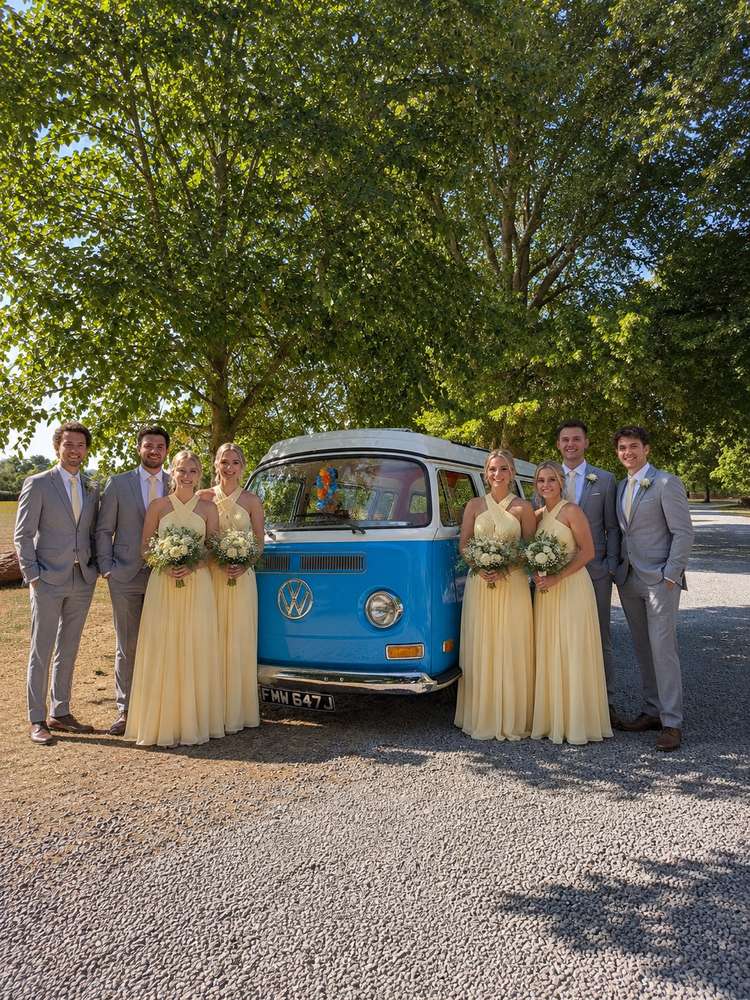 Bridesmaids in yellow, church tower behind.